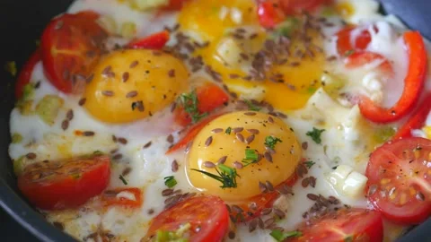 Fried eggs with vegetables prepared on frying pan Stock Footage 138962015