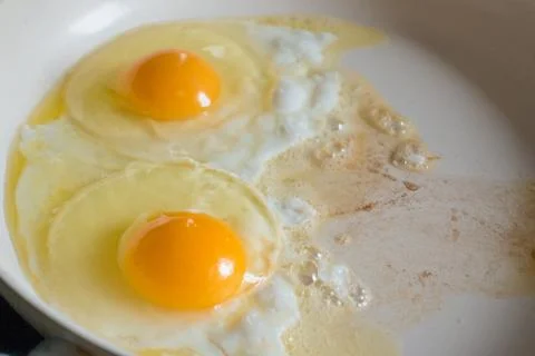 Fried eggs on the white ceramic pan Stock Photos