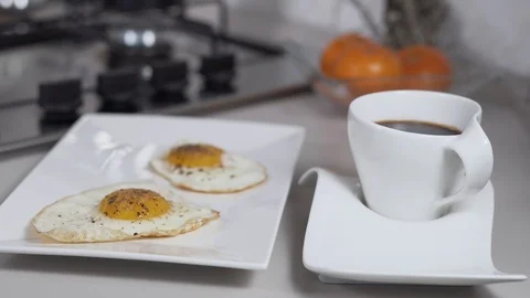 Fried eggs on a white plate with black coffee Stock Footage 127091895