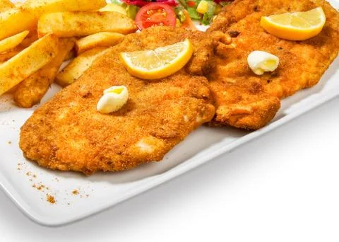 Fried fish in breadcrumbs with potatoes fries and vegetables Stock Photos