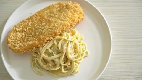 Fried fish fillet with cabbage and lemon on a plate Stock Photos