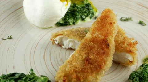 Fried fish fillet with soft poached egg and spinach, closeup, loop Stock Footage 66482322