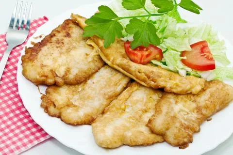 Fried fish fillets with egg and salad. Stock Photos