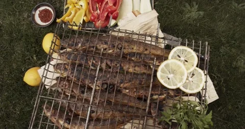 Fried fish grill, BBQ. Lemon, herbs, zucchini, paprika, spices View from above Stock Footage 146432219