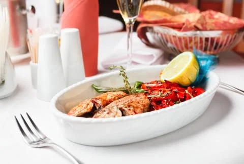 Fried fish with red peppers and lemon. Stock Photos