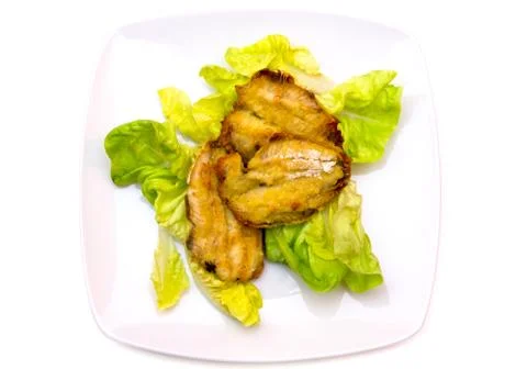 Fried fish on salad on white background seen from above Stock Photos