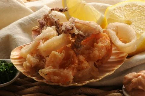 Fried fish in scallop shell with lemon slice. Foto stock