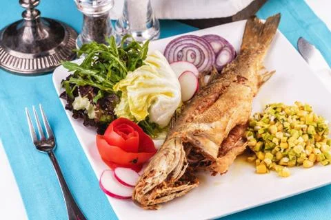 Fried fish served with vegetables Stock Photos