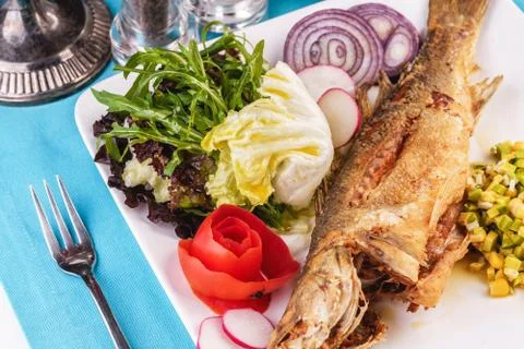 Fried fish served with vegetables Foto stock