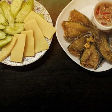 Fried fish, with shrimp paste and vegetables, placed on a white plate. Stock Photos