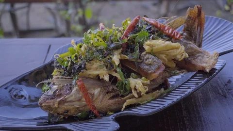 Fried fish squeezing lemon. Is a Thai food called striped bass fried fish sauce. Stock Footage 123605358