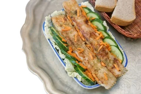 Fried fish with vegetables in a ceramic dish. Stock Photos