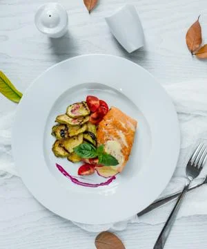 Fried fish with vegetables in the plate Stock Photos