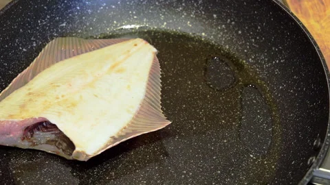 Fried flounder The cook arranges the fish on the pan for frying Food preparation Stock Footage 267900119