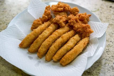 A fried food platter of crispy cod sticks and chicken nuggets Foto stock