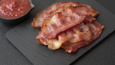 Fried fresh bacon slices with layers of meat or prosciutto with salt and spices. Stock-Footage 335377693