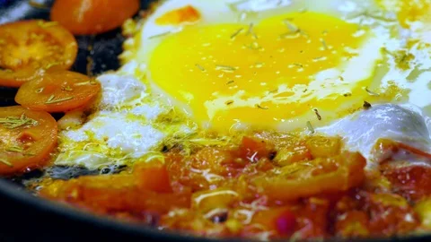 Fried fried eggs with cherry tomatoes sprinkled with seasoning Stock Footage 123820529