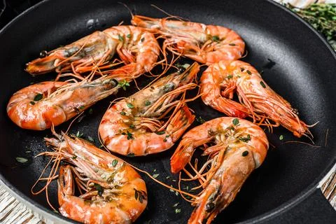 Fried giant tiger shrimps Prawns in a pan. White wooden background. Top view Stock Photos