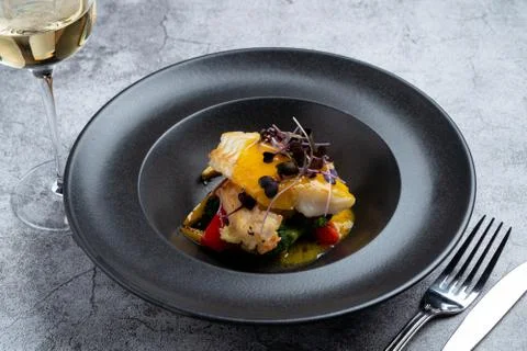 Fried halibut with mini vegetables and mango sauce as a creative chef's speci Stock Photos
