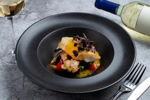 Fried halibut with mini vegetables and mango sauce as a creative chef's speci Stock Photos