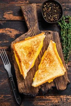 Fried ham and melted cheese sandwich. Dark wooden background. Top view Stock Photos
