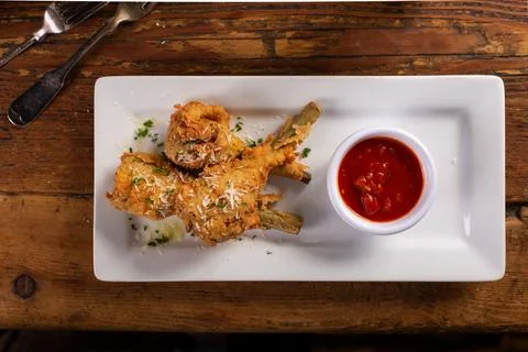 Fried lamb chops in parmesan batter with tomato sauce Stock Photos