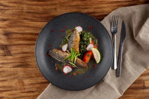 Fried mackerel fish with vegetable garnish: spinach in coconut milk, radish,  Stock-Fotos