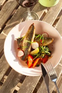 Fried mackerel fish with vegetable garnish: spinach in coconut milk, radish,  Stock-Fotos