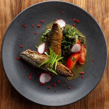 Fried mackerel fish with vegetable garnish: spinach in coconut milk, radish,  Stock-Fotos