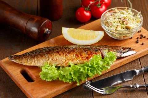 Fried mackerel with slice of lemon and lettuce Foto stock