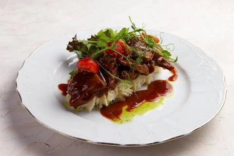 Fried meat on a bed of mashed potatoes. Stock Photos