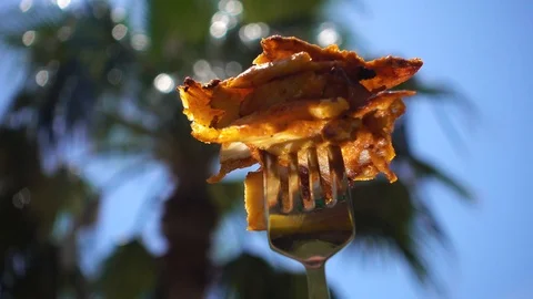 Fried meat, chicken meat, on a background of green palm and blue sky. The foo Stock Footage 95118542