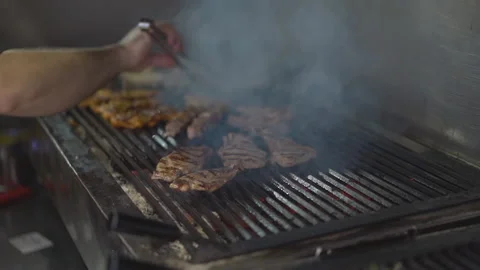 Fried meat cooked on hot grill in smoke and sparks Stock Footage 144454505