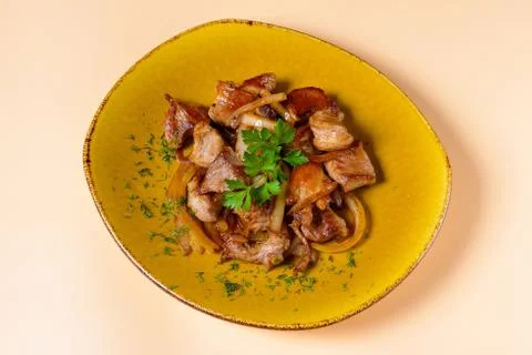 Fried meat with onions on plate Stock Photos