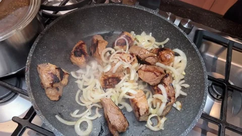 Fried meat in a pan with onion Stock Footage 232644313