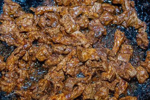 Fried meat slices close-up on a background of a frying pan base for paprikash Stock Photos