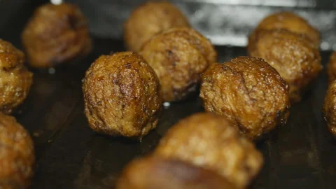 Fried meatballs on a baking sheet are illuminated by a movement of light in the Stock Footage 149026912