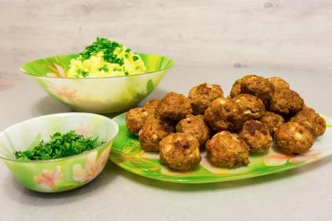 Fried meatballs with mashed potatoes and fresh herbs on a table Stock Photos