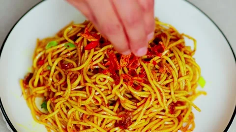 Fried noodles being sprinkled with crispy fried Stock Footage 329830893