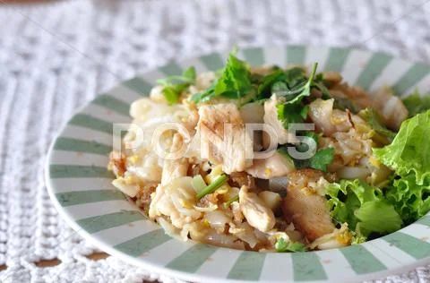 Fried noodles with roasted chicken on star-burst plate. Stock Photos