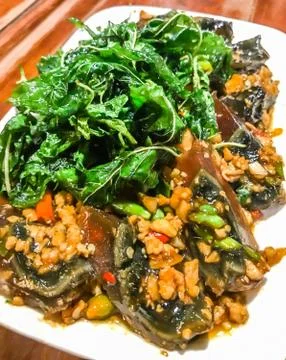 Fried one-thousand-year egg with crispy holy basil leaves and rice dish Stock Photos