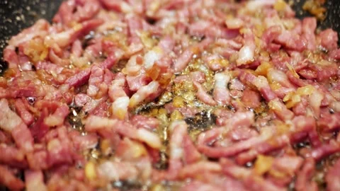 Fried onions with bacon Dishes frames. Close up of slices of bacon fried in a Stock Footage 151063830