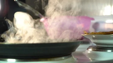 Fried pancake in a frying pan on the background of ready-made pancakes lying on  Stock Footage 85950959