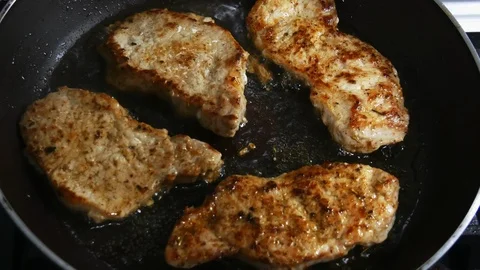 Fried pork chops in a skillet in boiling oil in close-up Stock Footage 102770518