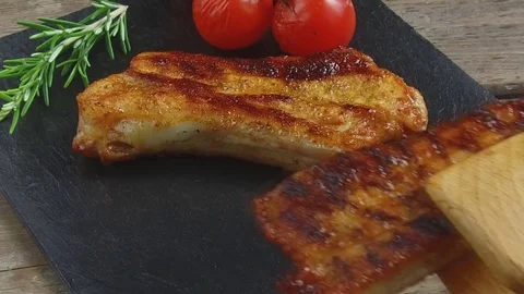 Fried pork ribs put on a portion board slow motion Video stock 77576076