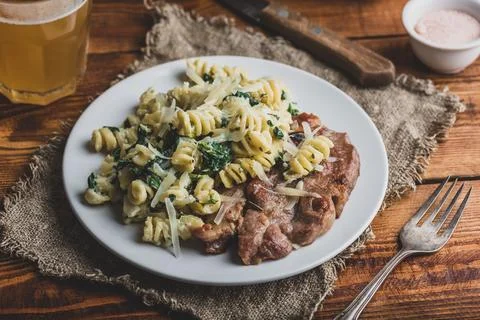Fried Pork Steak and Spinach Pasta Stock Photos