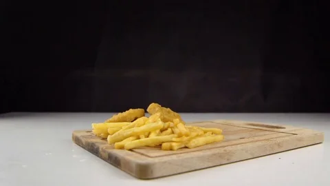 Fried potato chips falling down on hamburger, slow motion, fast food, junk food Stock Footage 77830885