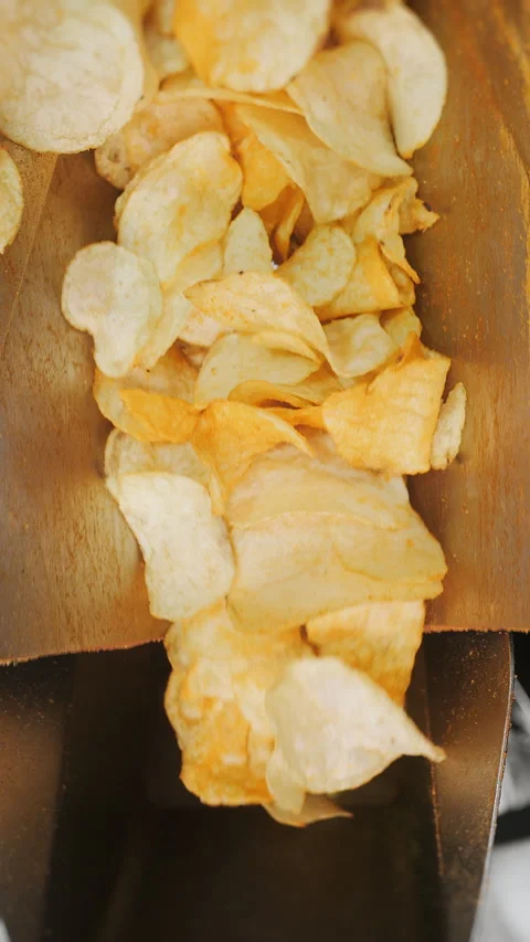 Fried potato chips falling into industrial conveyor at a factory. Stock Footage 313515860