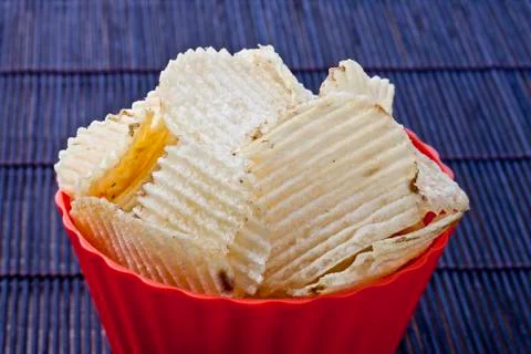 Fried potato chips in red plastic bowl Stock Photos
