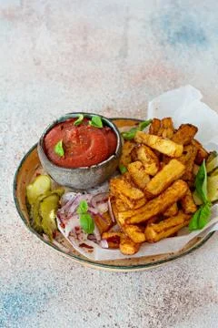 Fried potatoes (deep fried) with herbs and spices, ketchup, pickles Stock Photos